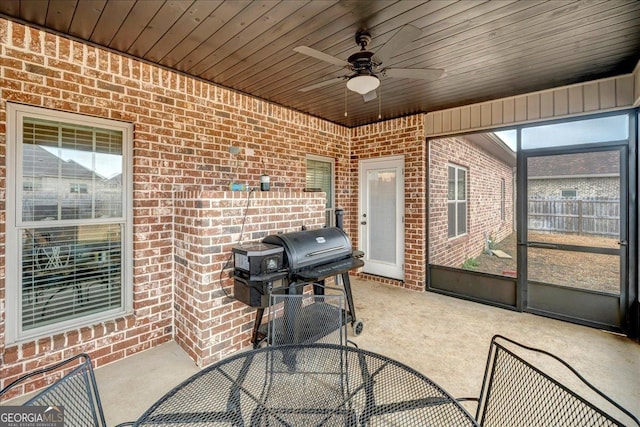 sunroom with ceiling fan and wood ceiling