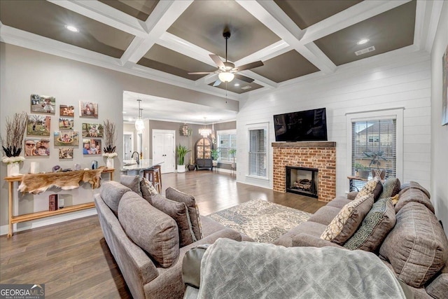 living room with beam ceiling, a fireplace, and coffered ceiling