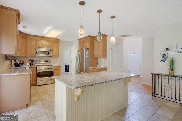 kitchen with a center island, hanging light fixtures, sink, a breakfast bar area, and stainless steel appliances