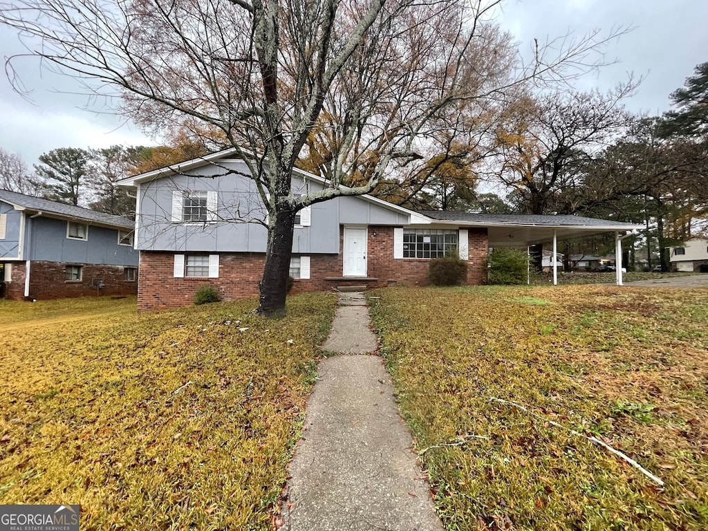 tri-level home featuring a carport and a front lawn