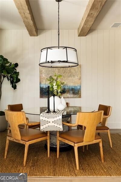 living room with a notable chandelier, beam ceiling, and light wood-type flooring