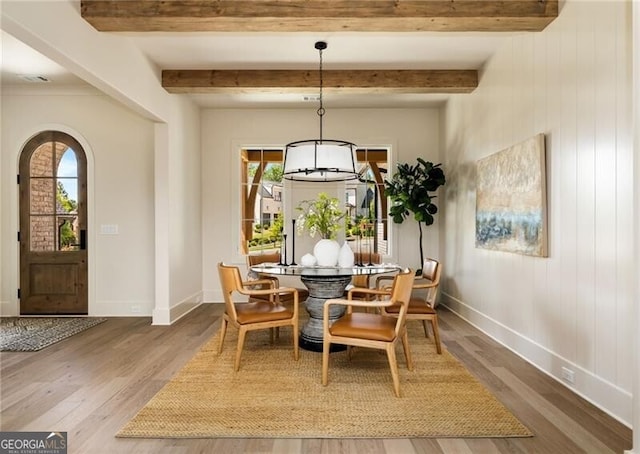 living area with wood-type flooring, built in features, a notable chandelier, and beam ceiling