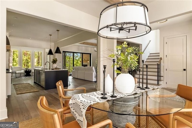 interior space featuring a notable chandelier, beam ceiling, and wood-type flooring