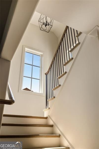 stairs featuring a notable chandelier