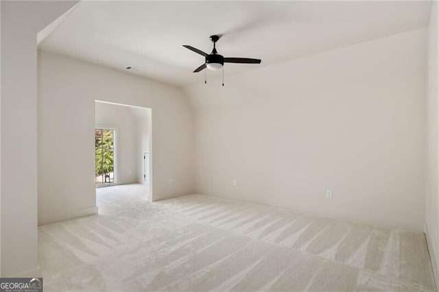 spare room with ceiling fan and light carpet