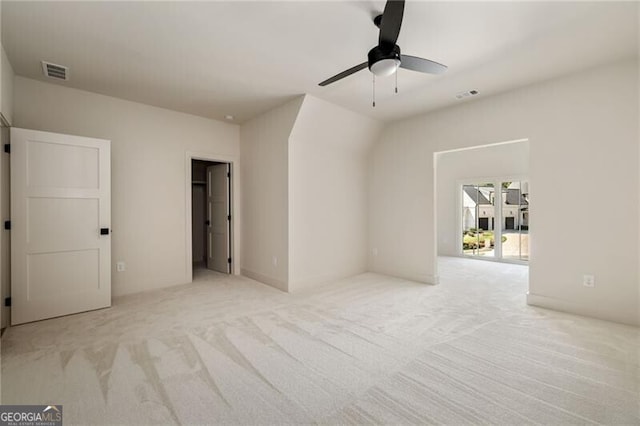 spare room featuring ceiling fan and light carpet