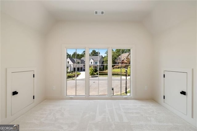 empty room with light carpet and lofted ceiling