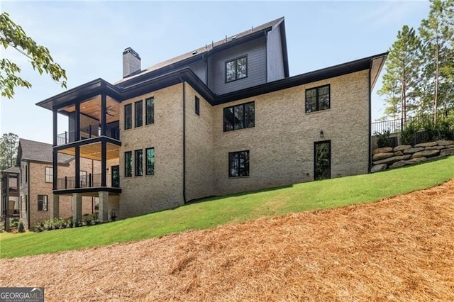 back of house with a balcony and a yard