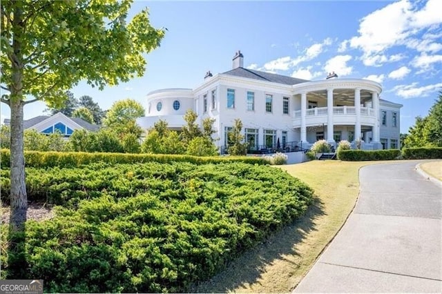 view of front of property with ceiling fan and a balcony