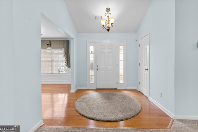 entrance foyer featuring a chandelier and lofted ceiling