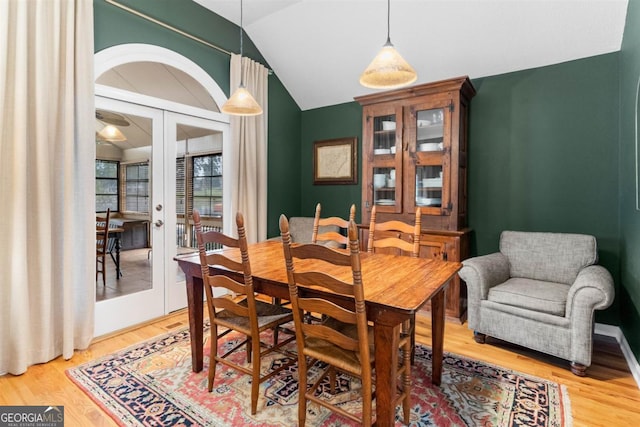 dining room with lofted ceiling, french doors, and wood finished floors