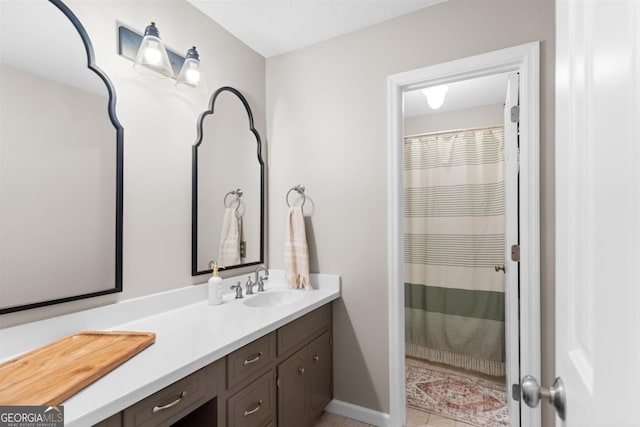 full bath featuring curtained shower, vanity, baseboards, and tile patterned floors