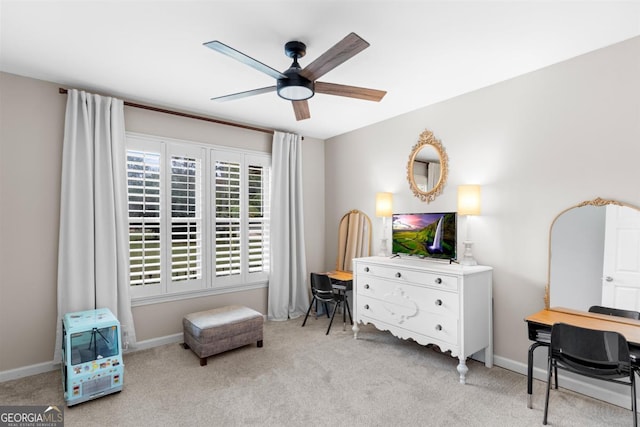 living area with baseboards, a ceiling fan, and light colored carpet