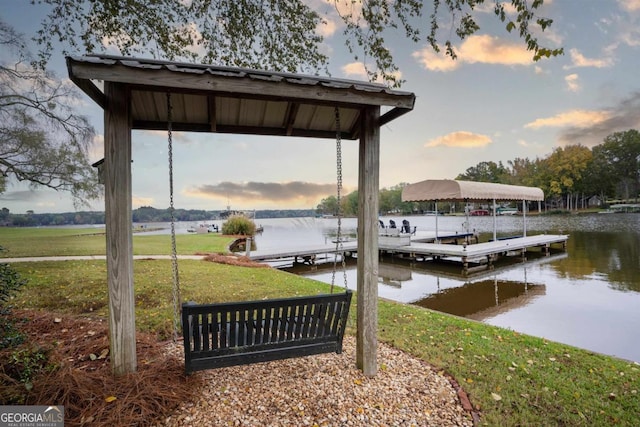 dock area featuring a water view, a yard, and boat lift