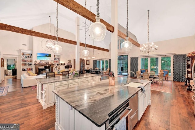 kitchen featuring a large island with sink, high vaulted ceiling, and pendant lighting