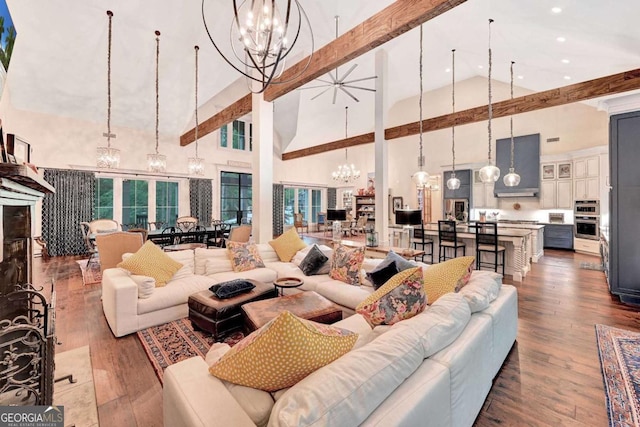 living room featuring a notable chandelier, wood-type flooring, and high vaulted ceiling