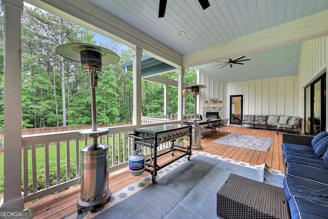 wooden deck featuring ceiling fan, a yard, and an outdoor living space