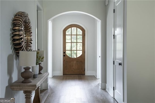 foyer with light wood-type flooring and crown molding