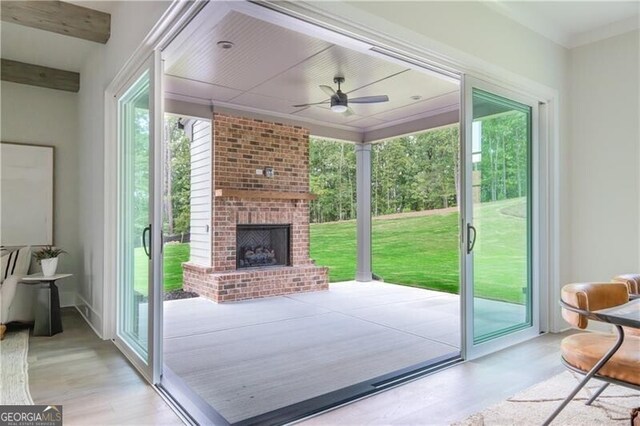 view of patio / terrace featuring an outdoor brick fireplace and ceiling fan