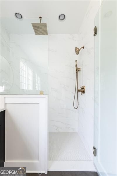 bathroom featuring vanity and a shower with door