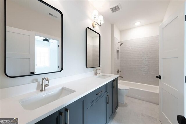 full bathroom featuring vanity, tile patterned floors, ceiling fan, tiled shower / bath combo, and toilet