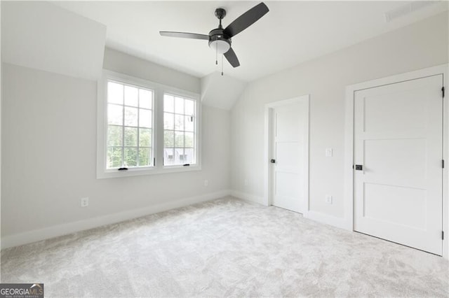 unfurnished bedroom featuring light carpet, vaulted ceiling, and ceiling fan