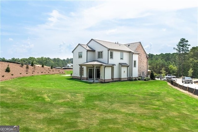 rear view of property with a lawn