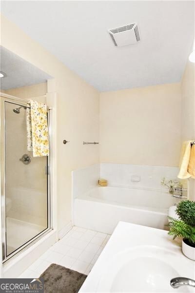 bathroom with independent shower and bath and tile patterned flooring