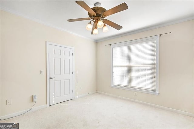 spare room featuring crown molding, ceiling fan, and light carpet