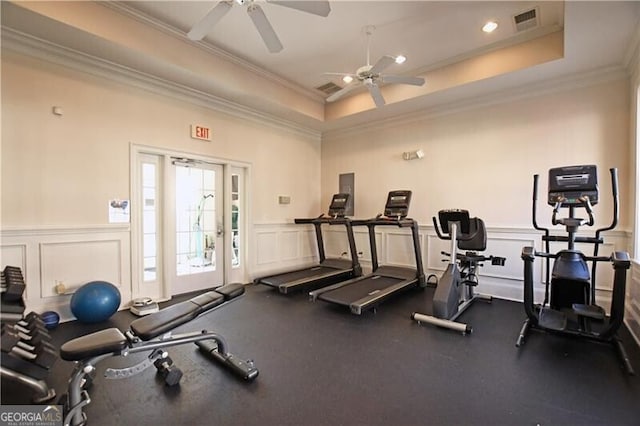 exercise room featuring crown molding, a tray ceiling, and ceiling fan