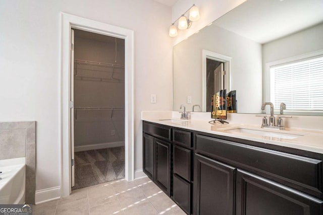 bathroom featuring tile patterned floors, vanity, and a tub to relax in