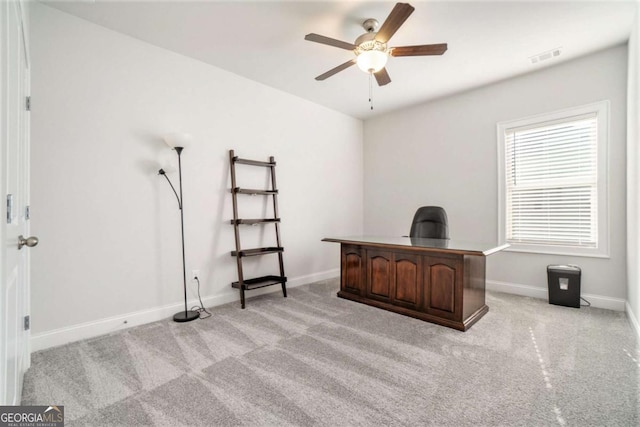 carpeted office space featuring ceiling fan