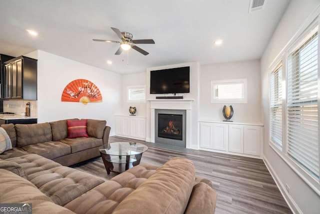 living room featuring dark hardwood / wood-style flooring and ceiling fan