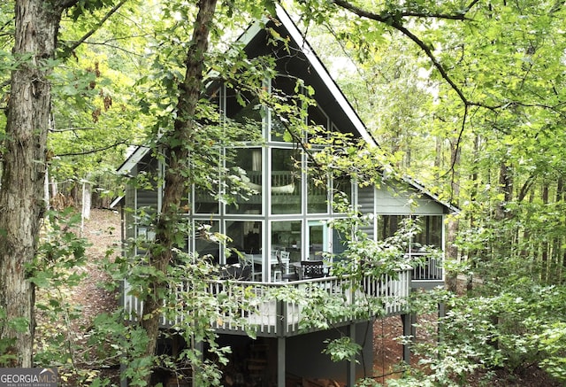 view of home's exterior with a deck and a sunroom