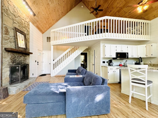 living room with a fireplace, high vaulted ceiling, ceiling fan, and wooden ceiling