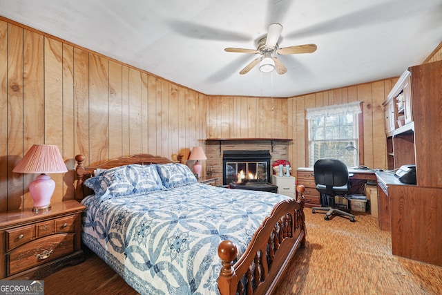 bedroom with wooden walls, light hardwood / wood-style floors, and ceiling fan