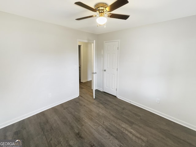 spare room with dark hardwood / wood-style flooring and ceiling fan