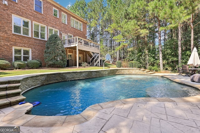 view of pool with a wooden deck and a patio area