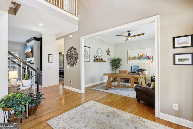 interior space with wood-type flooring, ceiling fan, and crown molding