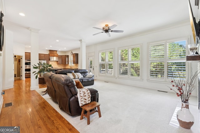 living room with plenty of natural light, ornamental molding, and ceiling fan