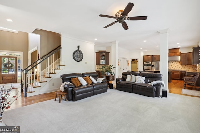 carpeted living room featuring ornate columns, ceiling fan, and ornamental molding