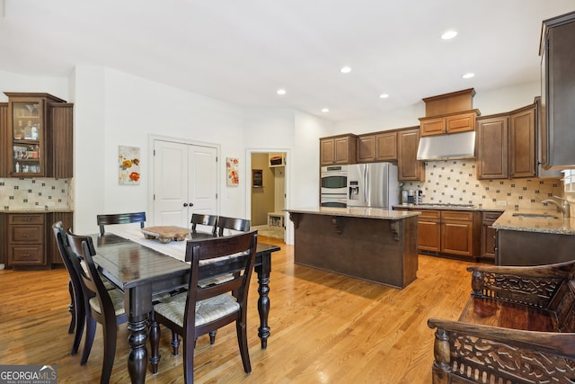 dining space featuring light wood-type flooring and sink