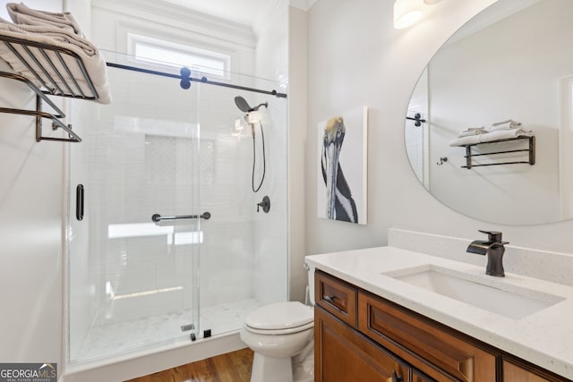 bathroom with hardwood / wood-style flooring, vanity, toilet, and a shower with door