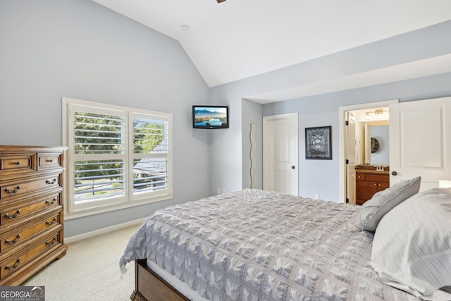 carpeted bedroom featuring connected bathroom and lofted ceiling