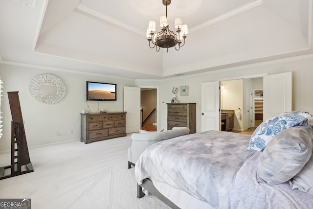 bedroom with a tray ceiling, ensuite bath, light colored carpet, and a notable chandelier