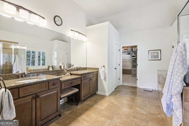 bathroom with vanity, walk in shower, and vaulted ceiling