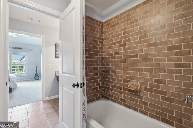 bathroom featuring tile patterned flooring and tiled shower / bath combo