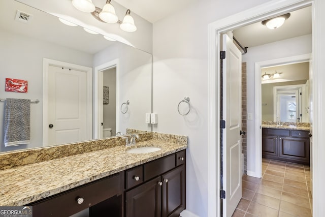 bathroom featuring toilet, vanity, and tile patterned floors