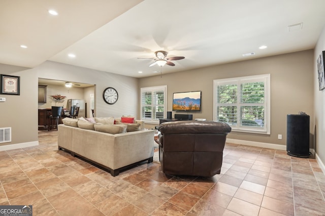 living room featuring ceiling fan and a wealth of natural light