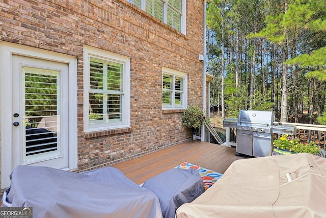 wooden terrace with an outdoor hangout area and a grill